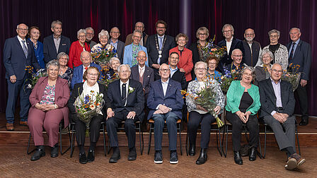 De vijftien echtparen staan samen met de burgemeester op deze groepsfoto. 
