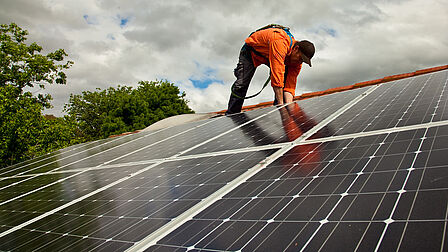 Installateur op het dak om zonnepanelen te installeren