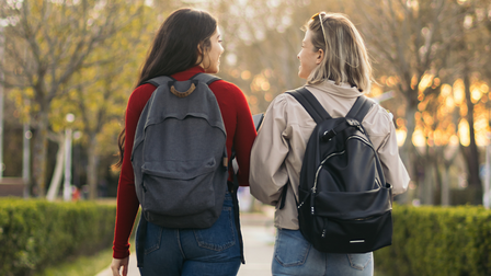 Twee vrouwen met rugzak lopen door het park