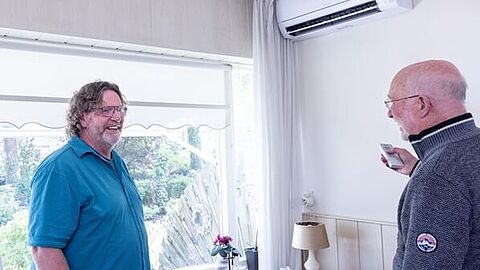 Energiecoach Peter (l) en Jaap bij de airco, die de temperatuur in huis regelt. (Foto: AG Heeremans Photography)
