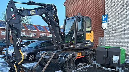 Mobiele graafmachine aan publieke laadpaal