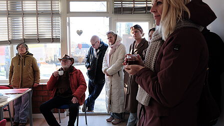 Bewoners en gebiedsverbinder zijn in gesprek met elkaar en staan in buurthuis de Ezel