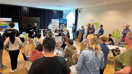 David Koenders geeft ene lezing op het podium voor een groep jonge toehoorders.