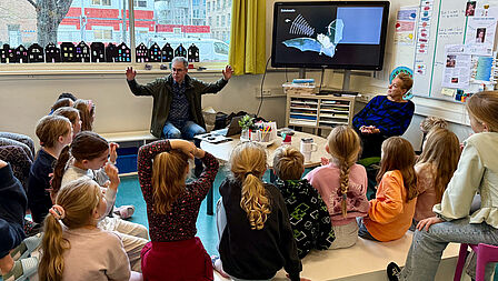 Kinderen luisteren geboeid naar ecoloog Huub die over vleermuizen vertelt