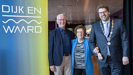 Het echtpaar Huibers staat samen met de burgemeester voor de ingang van het restaurant van theater Cool.