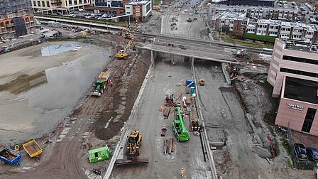 Grote bouwvoertuigen zijn bezig met de werkzaamheden aan de spooronderdoorgang